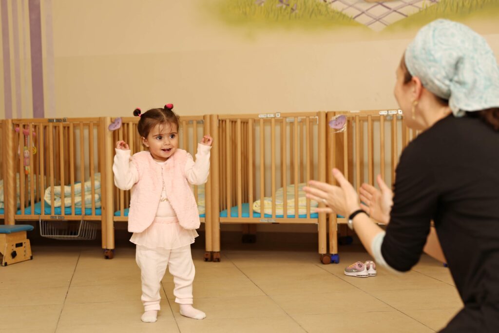 ילדה מתקבלת בידיים פתוחות על ידי הגננת בגני צלילים